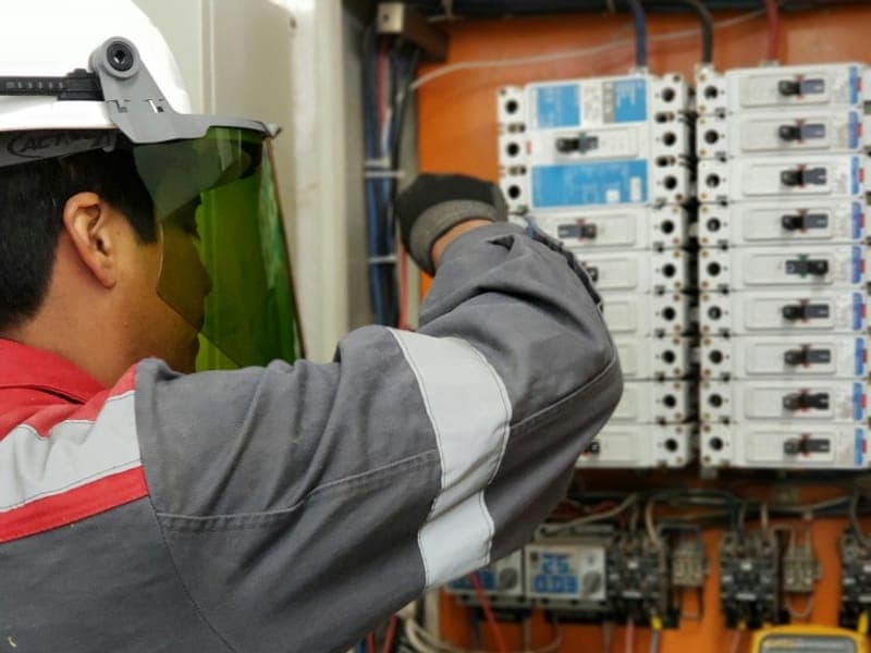 Electricista trabajando en un tablero eléctrico